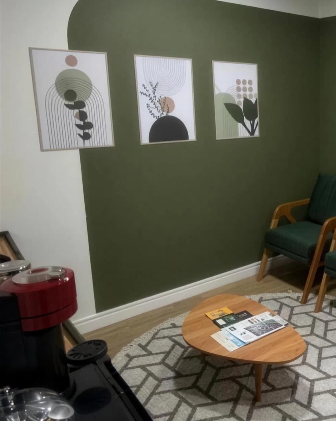 Área de espera com poltronas, mesa de centro e tapete, na antessala do consultório