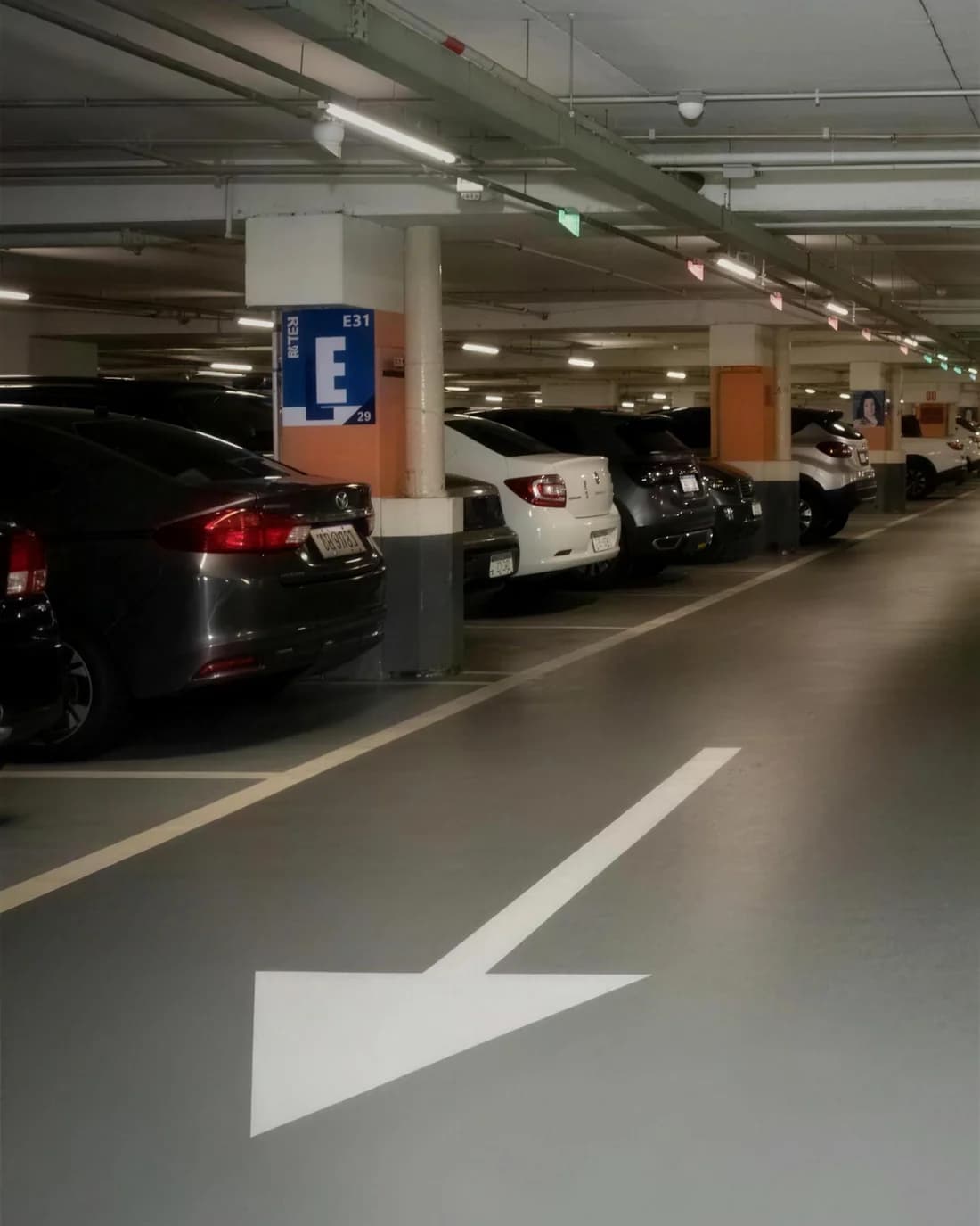 Estacionamento coberto no subsolo do edifício, com vagas sinalizadas
