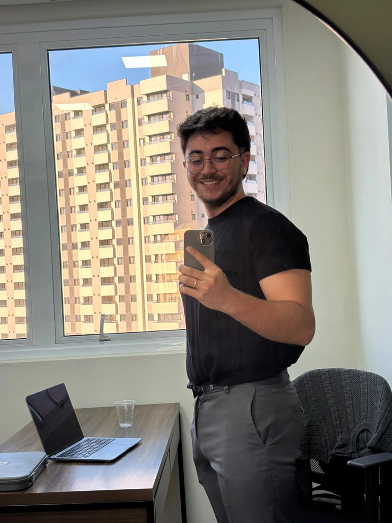 Luiz Macedo sorrindo junto à janela do consultório